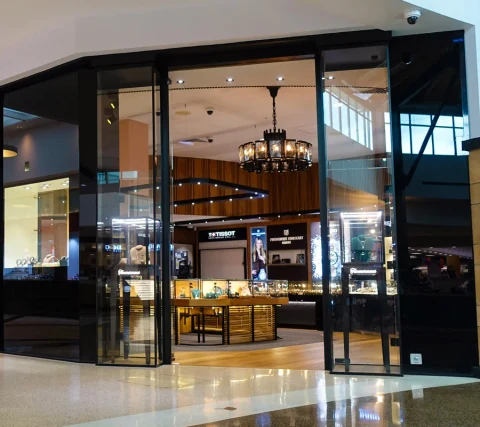 Black-framed glass entrance with tall glazed side panels.